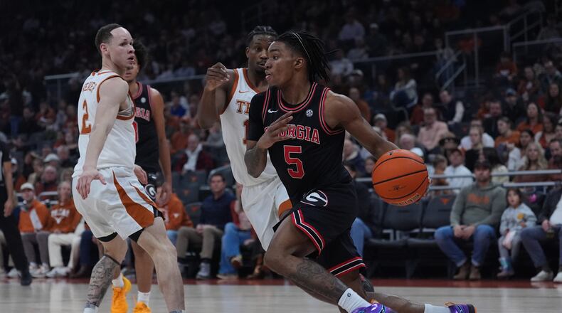 Georgia guard Jeremiah Wilkinson (right) drives around Texas guard Tramon Mark (center) during the first half Saturday, Jan. 24, 2026, in Austin, Texas. The Longhorns trailed 37-30 at halftime but beat the Bulldogs 87-67. (Eric Gay/AP)