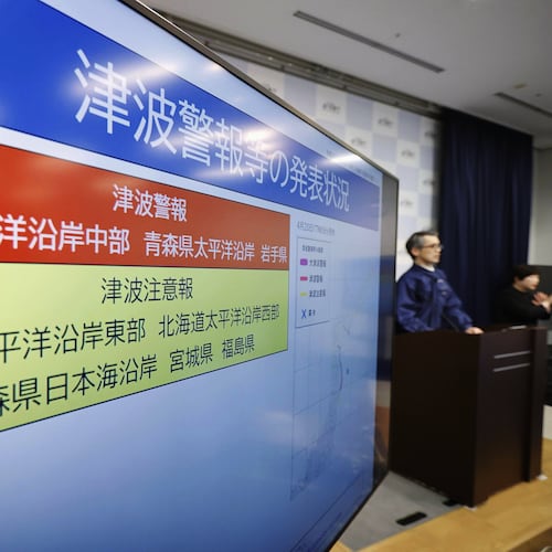 An official of the Japan Meteorological Agency speaks near a monitor showing a tsunami alert during a news conference at the agency in Tokyo, Monday, April 20, 2026, after an earthquake that struck off the northern Japanese coast. (Masanori Kumagai/Kyodo News via AP)
