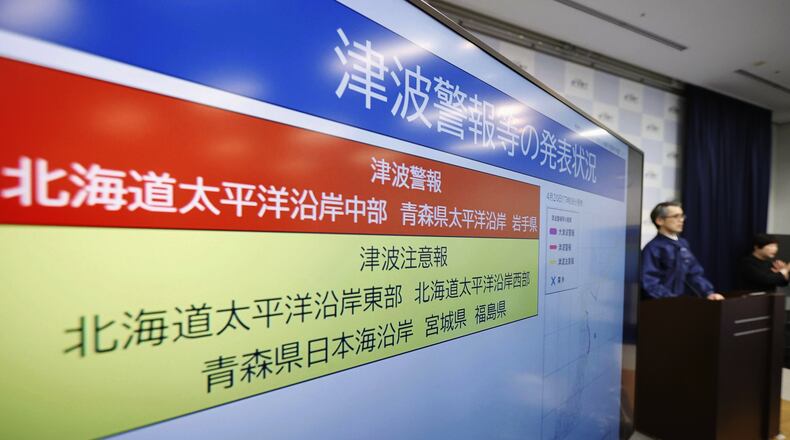 An official of the Japan Meteorological Agency speaks near a monitor showing a tsunami alert during a news conference at the agency in Tokyo, Monday, April 20, 2026, after an earthquake that struck off the northern Japanese coast. (Masanori Kumagai/Kyodo News via AP)