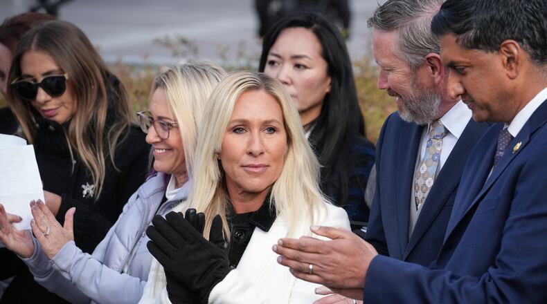 Rep. Marjorie Taylor-Greene, R-Ga., center, with Rep. Thomas Massie, R-Ky., second from right, and Rep. Ro Khanna, D-Calif., far right, applauds during a news conference as the House prepares to vote on the Epstein Files Transparency Act, at the Capitol in Washington, Tuesday, Nov. 18, 2025. (AP Photo/J. Scott Applewhite)