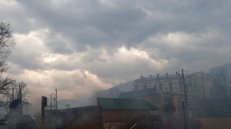 GATLINBURG, TN - NOVEMBER 30: Smoke fills the air and surrounds businesses and resorts in the wake of a wildfire November 30, 2016 in downtown Gatlinburg, Tennessee. Thousands of people have been evacuated from the area and over 100 houses and businesses were damaged or destroyed. Drought conditions and high winds helped the fire spread through the foothills of the Great Smoky Mountains. (Photo by Brian Blanco/Getty Images)