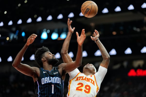 Atlanta Hawks guard Daeqwon Plowden (29) and Orlando Magic forward Jonathan Isaac (1) chase a rebound during the first half of an NBA basketball game, Sunday, April 13, 2025, in Atlanta. (AP Photo/Mike Stewart)