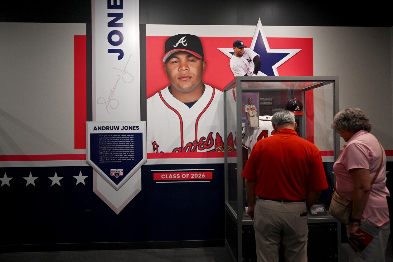 Baseball fans check out displays featuring former Atlanta Braves center fielder Andruw Jones at the National Baseball Hall of Fame and Museum on Friday, July 24, 2026, in Cooperstown, N.Y. Andruw Jones will be inducted into the National Baseball Hall of Fame on Sunday as part of the Class of 2026, alongside Carlos Beltrán and Jeff Kent. He is recognized as one of the greatest center fielders in baseball history. Jones will become the 12th player with ties to the Atlanta Braves to be inducted into the Hall of Fame. (Hyosub Shin/AJC)