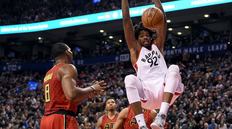 Toronto Raptors center Lucas Nogueira (92) dunks the ball as Atlanta Hawks center Dwight Howard (8) watches during the second half of an NBA basketball game Saturday, Dec. 3, 2016, in Toronto. (Frank Gunn/The Canadian Press via AP)