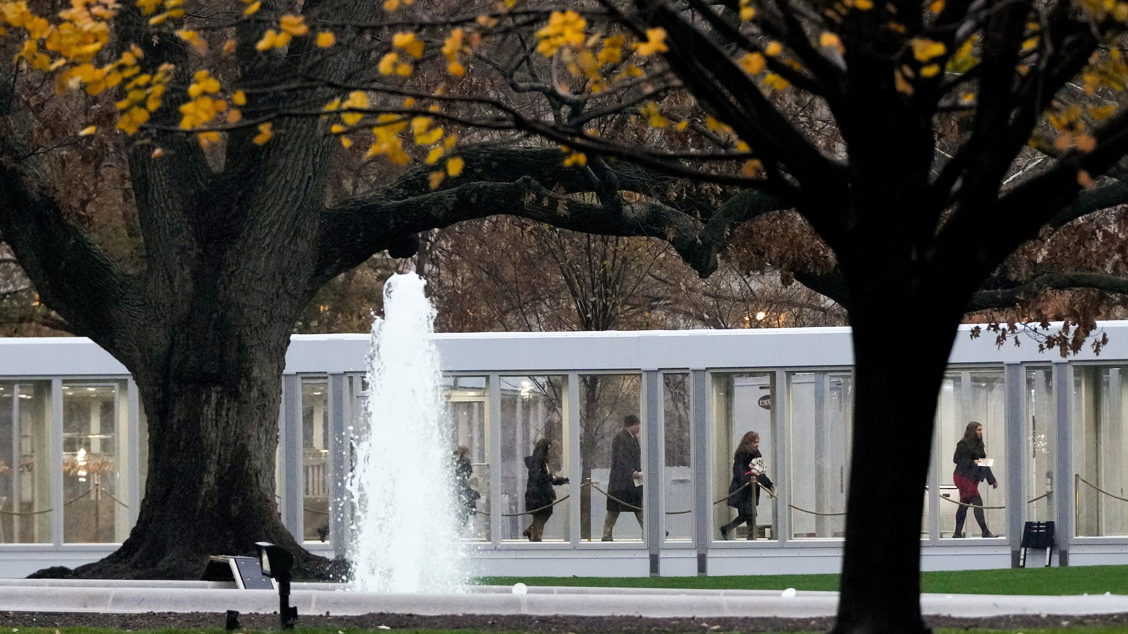 People walk through a newly constructed covered walkway on the North Lawn while arriving for a White House tour, Tuesday, Dec. 2, 2025, in Washington, as tours resume for the first time since construction of a new ballroom began at the White House. (AP Photo/Julia Demaree Nikhinson)