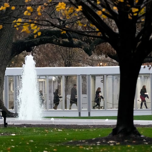 People walk through a newly constructed covered walkway on the North Lawn while arriving for a White House tour, Tuesday, Dec. 2, 2025, in Washington, as tours resume for the first time since construction of a new ballroom began at the White House. (AP Photo/Julia Demaree Nikhinson)