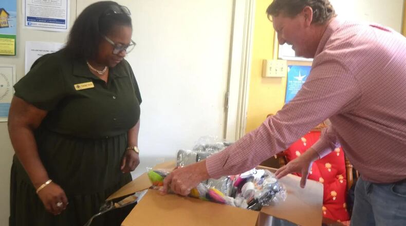 Tamaro Hayes, left, the HUD outreach director for Open Arms Inc., and Calhoun County farmer Chad Mathis, open a box of socks donated to the organization by the Georgia Cotton Commission. (Photo Courtesy of Alan Mauldin)