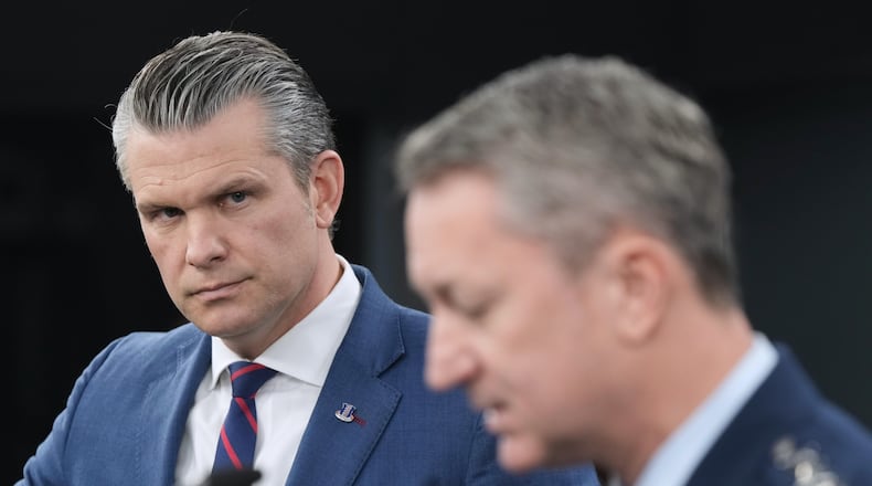 Defense Secretary Pete Hegseth listens to Chairman of the Joint Chiefs of Staff Gen. Dan Caine, during a press briefing at the Pentagon, Monday, March 2, 2026, in Washington. (AP Photo/Mark Schiefelbein)