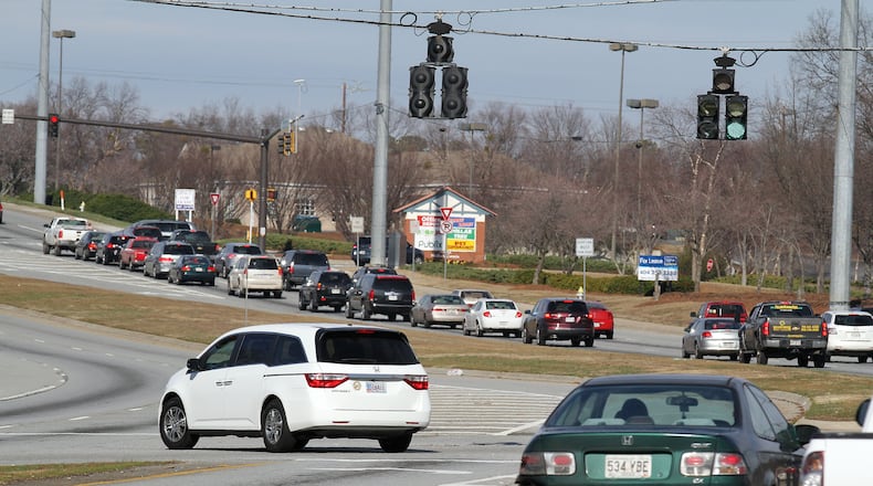 Jan. 19, 2012-JOHNS CREEK: A van (left) uses the West bound left turn lane on State Bridge Road as they turn into the State Bridge Corners shopping center near Home Depot in Johns Creek on Thursday Jan. 19, 2012. The City of Johns Creek will be installing new-fangled, left-turn signals at the intersection. Tens of thousands of commuters through north Fulton will serve as guinea pigs for a new traffic signal system that may make their drives safer and less troublesome. Johns Creek plans to be the first in the state to introduce flashing yellow left-turn signals along two of its most heavily traveled roads. The signals, already operating in about 30 other states, have been endorsed by the Federal Highway Administration as instrumental in reducing accidents at intersections. Phil Skinner pskinner@ajc.com