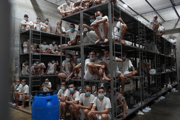 Prisoners look out from their cell as the Costa Rica Justice and Peace minister tours the Terrorist Confinement Center in Tecoluca, El Salvador, Friday, April 4, 2025. (AP Photo/Salvador Melendez)