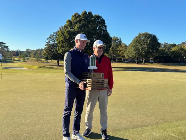 Dan Merriman (left) and his father Paul celebrated with the trophy for winning The Drew, Nov. 3, 2026, at East Lake Golf Club. Dan Merriman, the head professional at East Lake, earned a check for $50,000. (Stan Awtrey/AJC)