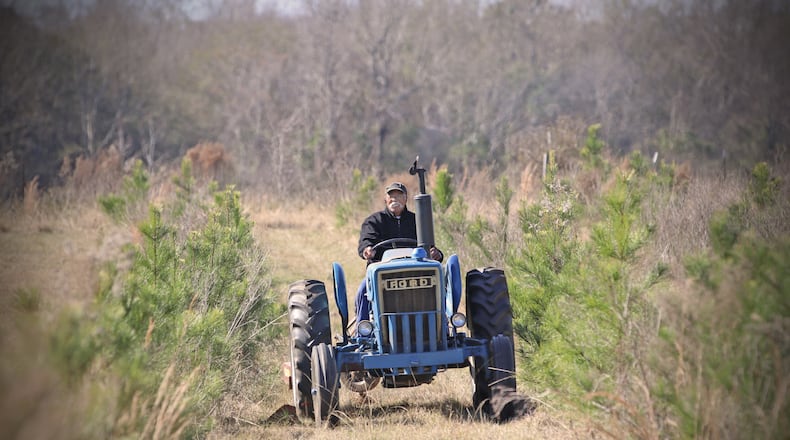 Cleveland Whitehead works on his tractor on his Flint River Farms property near Montezuma.
Courtesy of Eric Dusenbery