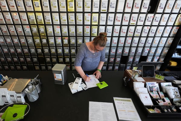 Owner Lisa McDonald packages loose leaf tea orders at the TeaHaus Thursday, April 24, 2025, in Ann Arbor, Mich. (AP Photo/Paul Sancya)