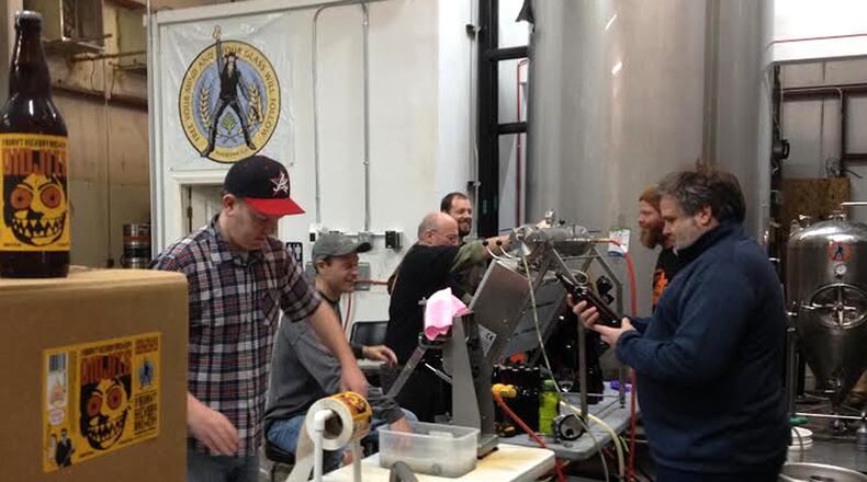 The crew at Burnt Hickory Brewery in Kennesaw bottles the Didjits Blood Orange IPA, with owner-brewmaster Scott Hedeen (right). Contributed.