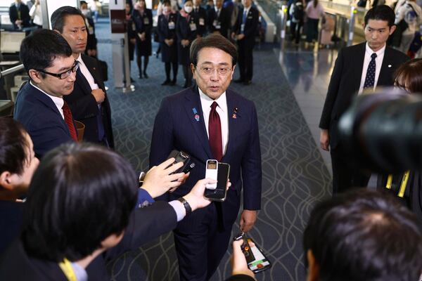 Japan's chief trade negotiator and Economic Revitalization Minister Ryosei Akazawa, center, speaks to the reporters before this departure for the U.S., at Haneda airport in Tokyo, Wednesday, April 16, 2025. (Kyodo News via AP)