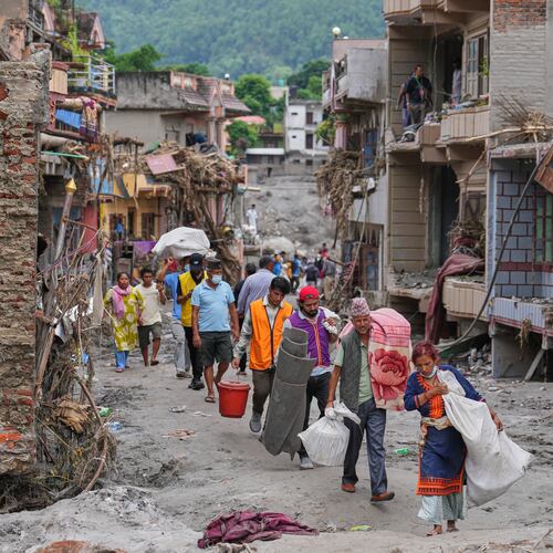 Residents carry their belongings salvaged from their damaged homes filled with mud and debris in Devighat, in Nepal's Nuwakot district, Saturday, Aug. 29, 2026, following the Aug. 26 flash floods. (AP Photo/Rajesh Kumar Singh)