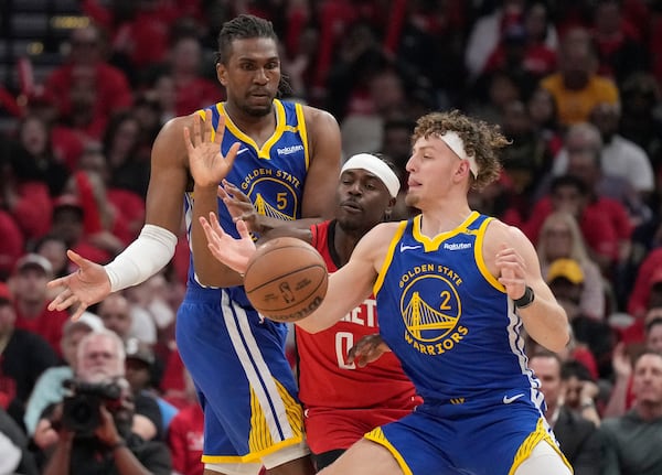 Golden State Warriors guard Brandin Podziemski (2) tries to get control of a ball against Houston Rockets guard Aaron Holiday (0) as Warriors forward Kevon Looney (5) looks on during the first half of Game 2 of an NBA basketball first-round playoff series against the Houston Rockets in Houston, Wednesday, April 23, 2025. (AP Photo/Karen Warren)