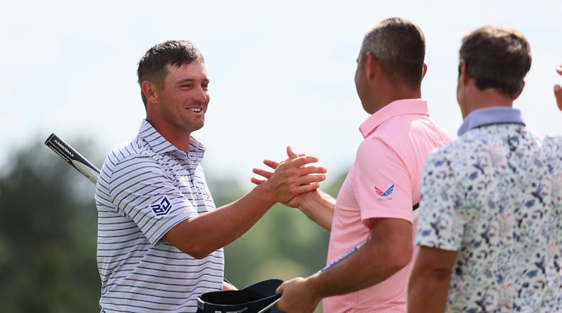 Bryson DeChambeau greets Gary Woodland as he finishes the first round at the 2024 Masters Tournament at Augusta National Golf Club, Thursday, April 11, 2024, in Augusta, Ga. Jason Getz / Jason.Getz@ajc.com)