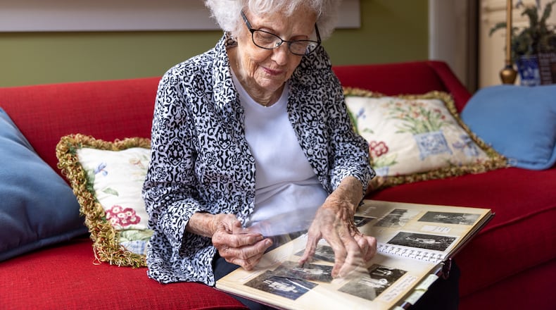 Plains resident Allene Haugabook, 93, showcases a scrapbook with photos taken during World War II on Saturday, February 25, 2023. In some of the photos she’s wearing clothes lent to her by Jimmy Carter's sister. (Arvin Temkar / arvin.temkar@ajc.com)