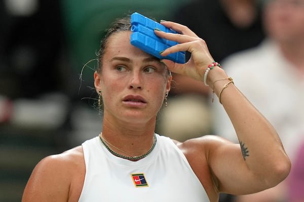 Aryna Sabalenka of Belarus uses an ice pack to keep cool during a change of ends break as she plays Belgium's Elise Mertens during a fourth round women's singles match at the Wimbledon Tennis Championships in London, Sunday, July 6, 2025. (AP Photo/Alastair Grant)