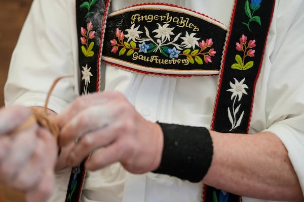 A competitor warms up for his bout while he try to pull the opponent over the table at the German Championships in Fingerhakeln or finger wrestling, in Pang, near Rosenheim, Germany, Sunday, April 27, 2025. (AP Photo/Matthias Schrader)