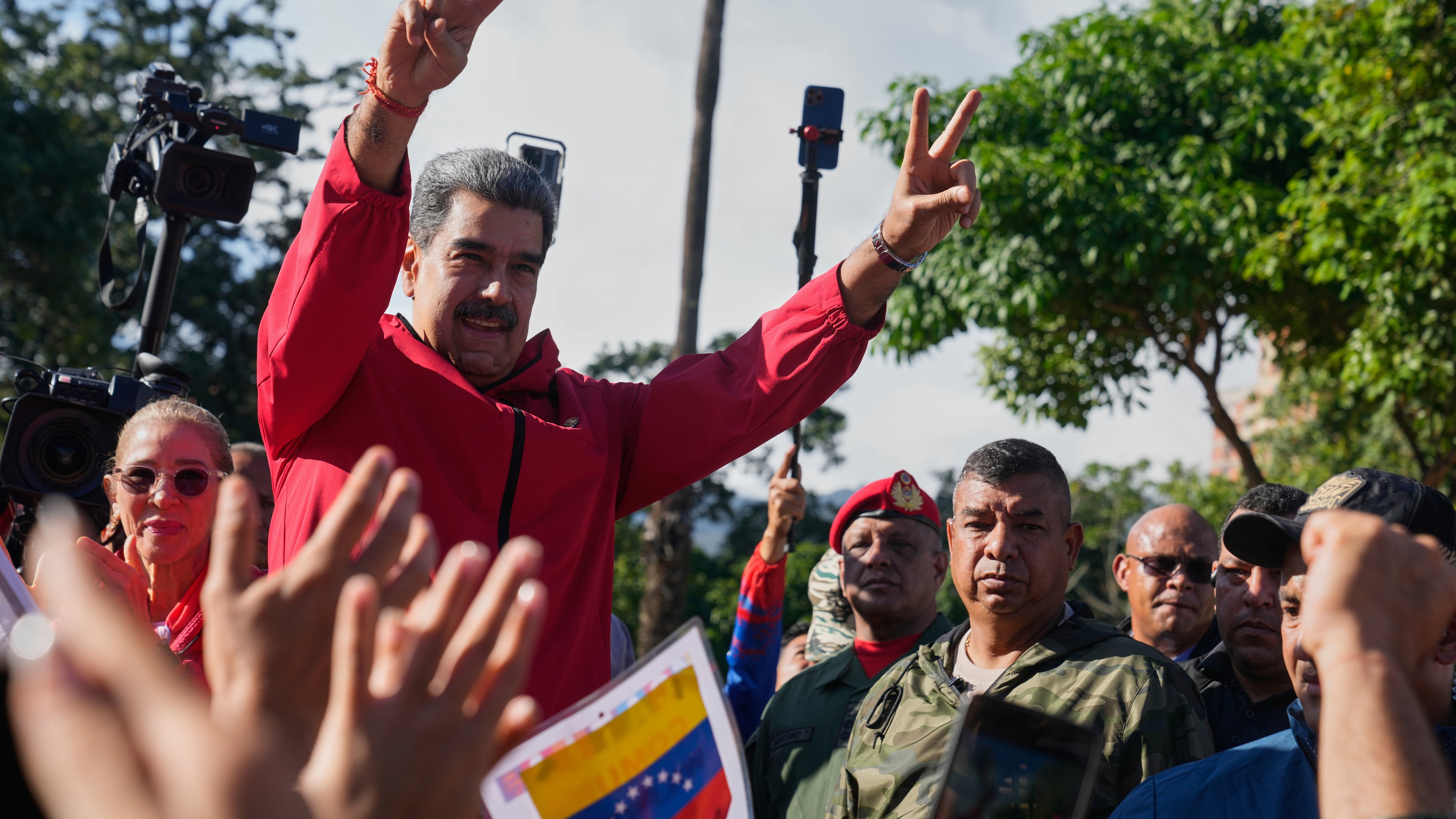 President Nicolas Maduro flashes victory signs during Indigenous Day in Caracas, Venezuela, Sunday, Oct 12, 2025. (AP Photo/Ariana Cubillos)