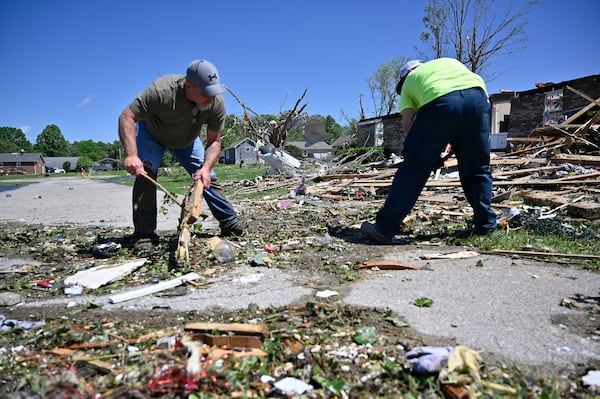 Volunteers help clear debris from a road following severe storms last night in London, Ky., Saturday, May 17, 2025. (AP Photo/Timothy D. Easley)