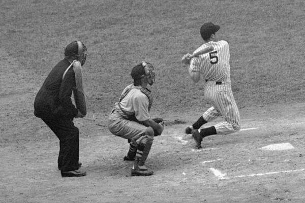 FILE - New York Yankees' Joe DiMaggio singles to center in the first inning of the nightcap of a doubleheader with the Boston Red Sox at Yankee Stadium on July 2, 1941. The hit ran his consecutive hitting streak to 44 games, equaling the record set in 1897 by Willie Keeler. The Boston catcher is Johnny Peacock with Joe Rue umpiring. (AP Photo/File)