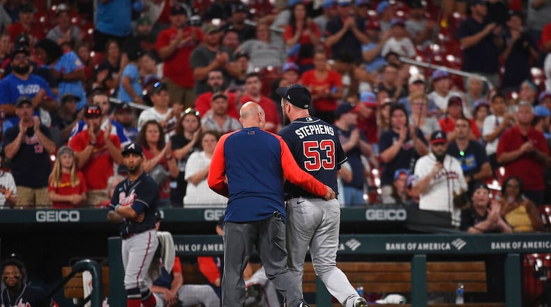 Braves relief pitcher Jackson Stephens (53) is helped off the field by training staff after being hit by a line-drive by St. Louis Cardinals' Brendan Donovan (33) in the ninth inning of a baseball game against the Atlanta Braves on Friday, Aug. 26, 2022, in St. Louis. (AP Photo/Joe Puetz)