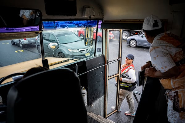 An instructor checks in on students practicing in a school bus at the Driving Academy on Tuesday, June 10, 2025 in Linden, N.J., where students prepare to obtain a Commercial Driver’s License (CDL) with multilingual instructors. (AP Photo/Angelina Katsanis)