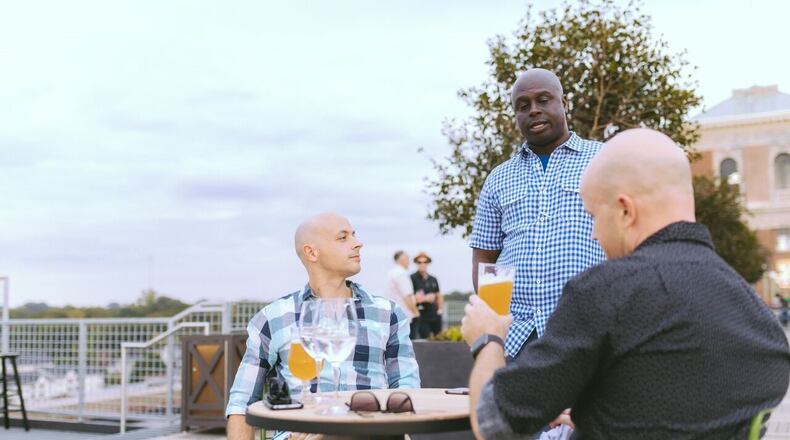 Kelvin Slater, president of Slater Hospitality, greets guests at Nine Mile Station, the beer garden on the roof of Ponce City Market that he and Amanda Slater opened with the help of a loan guaranteed by the U.S. Small Business Administration. PHOTO CREDIT: Evan West