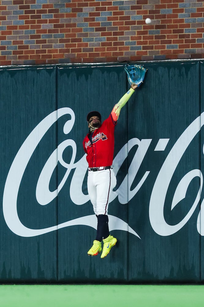 Braves outfielder Ronald Acuña Jr. attempts a catch against the Phillies at Truist Park on Friday, June 27, 2025, in Atlanta. (Abbey Cutrer/AJC)
