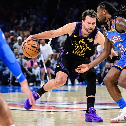 Los Angeles Lakers forward/guard Luka Dončić (77) drives against Oklahoma City Thunder guard Cason Wallace (22) during the first half of an NBA basketball game Thursday, April. 2, 2026, in Oklahoma City. (AP Photo/Gerald Leong)