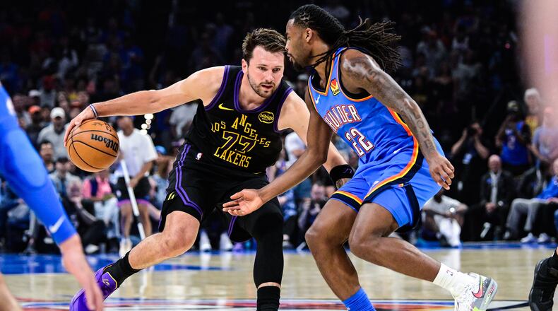 Los Angeles Lakers forward/guard Luka Dončić (77) drives against Oklahoma City Thunder guard Cason Wallace (22) during the first half of an NBA basketball game Thursday, April. 2, 2026, in Oklahoma City. (AP Photo/Gerald Leong)