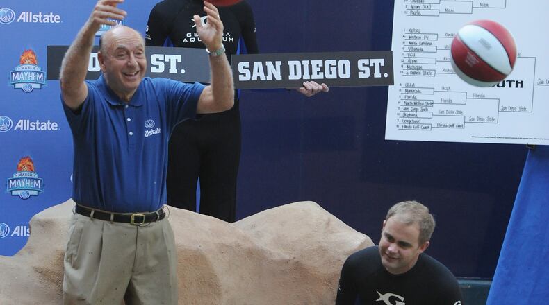 Dick Vitale throws basketball to Kei, dolphin, at the Georgia Aquarium on Tuesday, March 19, 2013. Vitale was at the Georgia Aquarium on Tuesday to put his college basketball acumen to the test against 11 dolphins.