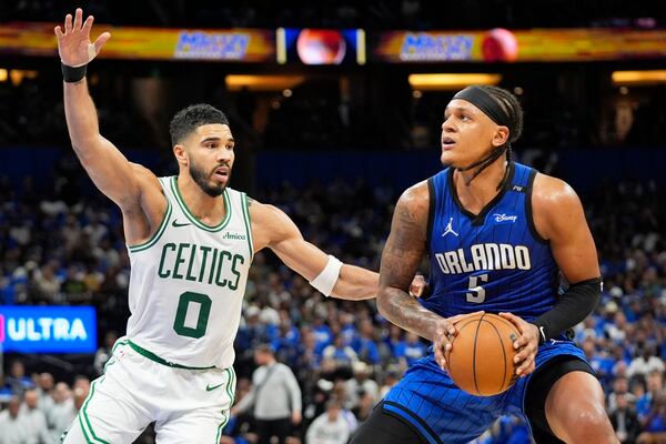 Orlando Magic forward Paolo Banchero, right, lines up a shot against Boston Celtics forward Jayson Tatum (0) during the second half in game 3 of a first-round NBA playoff basketball series,, Friday, April 25, 2025, in Orlando, Fla. (AP Photo/John Raoux)