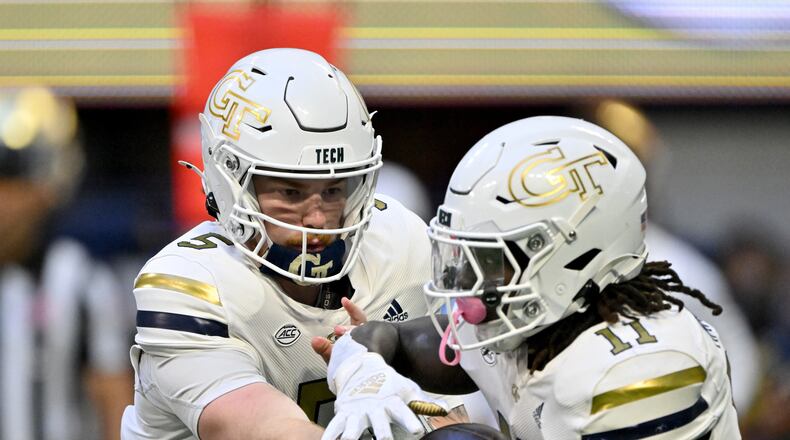 Georgia Tech quarterback Zach Pyron (5) makes a handoff to Georgia Tech running back Jamal Haynes (11) during the second half in an NCAA football game at Mercedes-Benz Stadium, Saturday, October 19, 2024, in Atlanta. Notre Dame won 31-13 over Georgia Tech. (Hyosub Shin / AJC)