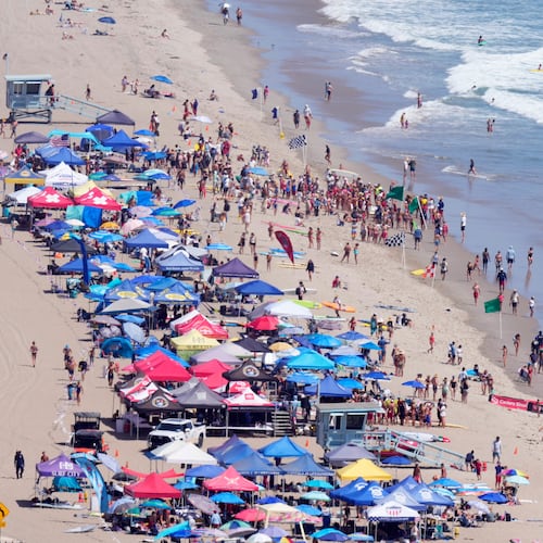 Beach goers watch during the the 46th Annual California Surf Lifesaving Championships on Will Rogers State Beach Friday, July 24, 2026, in the Pacific Palisades section of Los Angeles. (AP Photo/Mark J. Terrill)