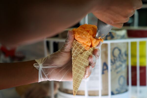 An employee with the ice cream shop the Frosty Caboose makes an orange sherbet ice cream cone, Monday, July 8, 2024, in Chamblee, Ga. (Jason Getz/AJC)
