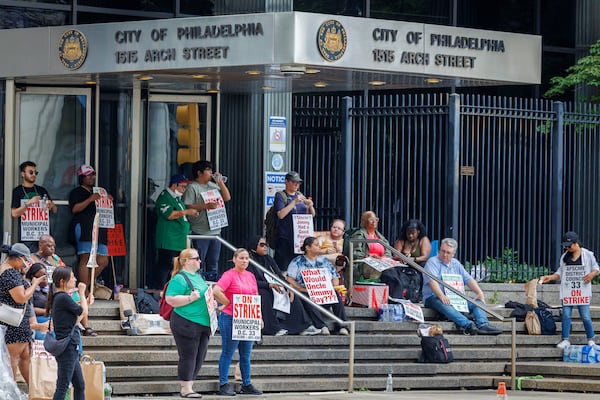 People hold signs on the first day of strike by the Philadelphia municipal workers, AFSCME District Council 33 outside municipal offices on Tuesday, July 1, 2025. (Alejandro A Alvarez/The Philadelphia Inquirer via AP)