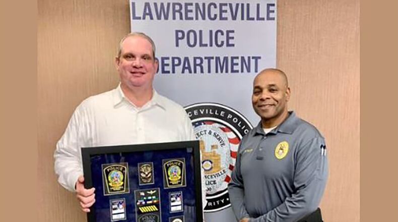 Lawrenceville Police Captain Ryan Morgan, left, seen here as the department celebrated his retirement in December 2021. He's pictured with Major Myron Walker, right, the agency's assistant chief. Morgan informed the city of his decision to retire the night before he was set to be interviewed by an independent investigator looking into sexual harassment within the agency.