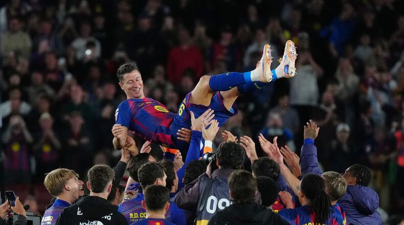 Barcelona's Robert Lewandowski is thrown into the air by his teammates after his last game for the club at the end of the Spanish La Liga soccer match between FC Barcelona and Real Betis in Barcelona, Spain, Sunday, May 17, 2026. (AP Photo/Joan Mateu Parra)