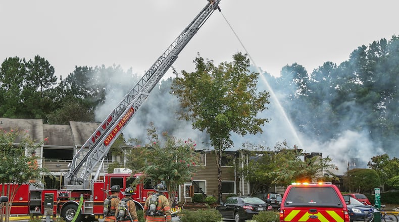 APARTMENT EXPLOSION INJURES 3-- August 31, 2015 Marietta: Marietta firefighters work to extinguish the flames at the Crestmont apartments at 500 Williams Drive in Marietta Monday, Aug. 31, 2015. Witnesses said an explosion ignited the fire that sent multiple residents of a Marietta apartment complex to the hospital Monday morning, Aug. 31, 2015. Marietta Fire Department Assistant Chief Tim Milligan said firefighters were dispatched to the Crestmont apartments at 500 Williams Drive at about 10:15 a.m. Monday after receiving multiple 911 calls. At least two of those callers said there had been an explosion. City of Marietta spokeswoman Lindsey Wiles said three people were taken to the hospital. Two residents had to be rescued from the 24-unit building, and a third resident had "significant" injuries after jumping from the second story, Milligan said. "I heard the blow up, and I went back to sleep," Ann Anderson, who lives in a neighboring building, said. "As I heard more and more screaming, I opened my door to the porch and went outside, and everybody was running and fire trucks were pulling in. � I literally almost had a heart attack." Resident Angel North escaped with her 3-year-old daughter after hearing the explosion, which she believed came from the apartment below her. Wood, nails and insulation were strewn about the stairway. "The future's kind of a big question mark, but I know that I have support so I'm not overly depressed about that," North said. As of noon, firefighters from the city of Marietta and Cobb County were still working to extinguish the flames. The building sustained "a lot of structural damage," but all residents were accounted for, Milligan said. "At this point we're just trying to get the fire completely out so our investigators can start their job and figure out why the fire started," he said. The Red Cross was on the scene to assist displaced families. JOHN SPINK / JSPINK@AJC.COM