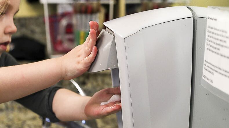 A Kids R Kids Learning Academy day care student washes her hands at the Marietta center following snack time Tuesday. With flu season taking hold in Georgia, hand-washing is important for everyone. ALYSSA POINTER/ ALYSSA.POINTER@AJC.COM