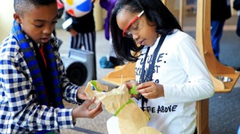 Jeffrey Walker (left) and Mallory Holmes (right) participate in interactive activities during the Gwinnett science fair at the Infinite Energy Center in Duluth, Georgia in February. CHRISTINA MATACOTTA for The Atlanta Journal-Constitution
