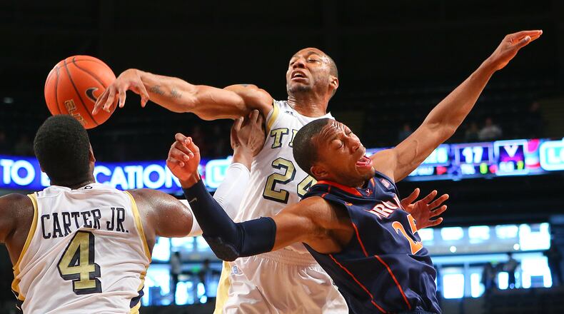 020313 ATLANTA: Georgia Tech forward Kammeon Holsey (center) and Virginia forward Akil Mitchell battle for a rebound during the first half of their NCAA college basketball game on Sunday, Feb. 3, 2013, in Atlanta. CURTIS COMPTON / CCOMPTON@AJC.COM