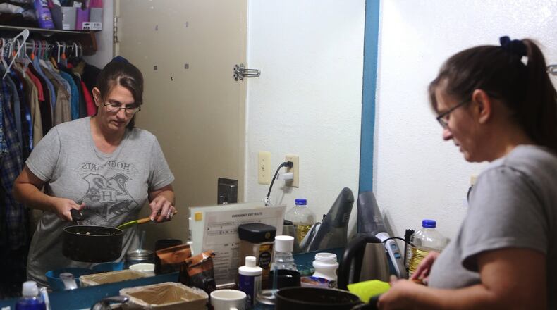 Rimbey Schroeder, 44, cooks lunch for her three daughters at Motel 6 on Peachtree Industrial Boulevard on Tuesday, July 2, 2019. The Schroeder family has lived in their Motel 6 room for nearly a year after moving from California and living in their car for several months. The family will move into a Lawrenceville apartment in a few weeks. CHRISTINA MATACOTTA/CHRISTINA.MATACOTTA@AJC.COM