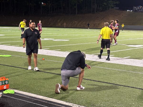 Coach Matt Cheaves drops to his knee to give thanks after Dalton defeated Midtown 1-0 for the Class 4A soccer championship, May 15, 2016, at Duluth High School.