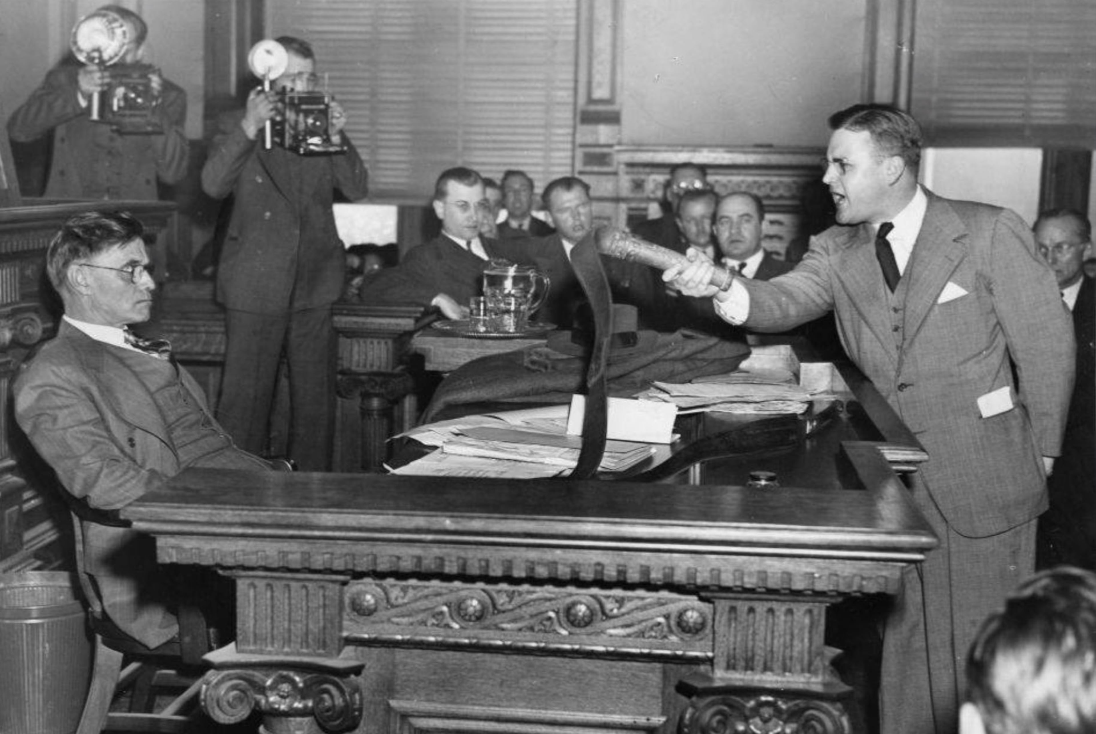 Attorney Dan Duke (right) confronts Georgia Gov. Eugene Talmadge in 1941 over the governor's desire to grant clemency to KKK members convicted of a series of assaults. Duke is holding a whip used by KKK members to beat Black people. (AJC file)