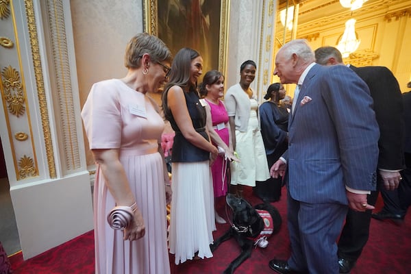 Britain's King Charles III greets Vicky Pattison during a reception in Buckingham Palace, London, in celebration of community-based initiatives raising awareness about cancer and supporting those living with cancer, Wednesday April 30, 2025. (Yui Mok/Pool Photo via AP)